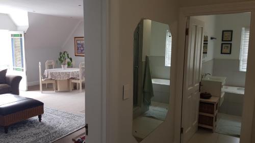 a living room with a mirror and a room with a table at Mountain View Self-Catering Apartment in Somerset West