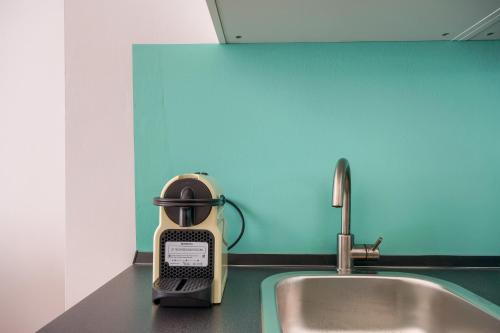 uma torradeira sentada num balcão de cozinha ao lado de um lavatório em [LE CURE] Large apt, 6+1 beds. Center 15 min far by bus. em Florença