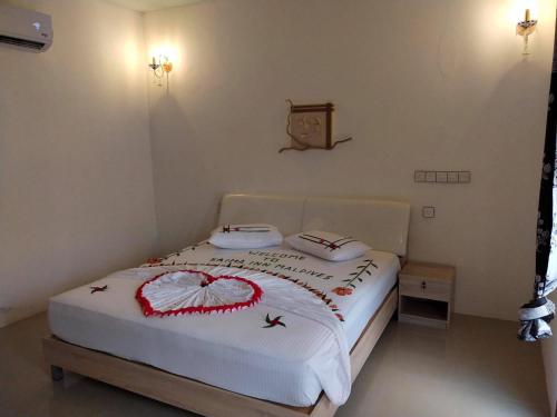 a bedroom with a bed with a heart decoration on it at Saima Inn in Maalhos