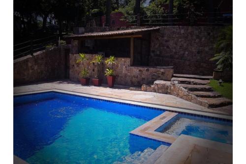 uma piscina com água azul num quintal em OYO Pousada e Hotel Putini em São Roque