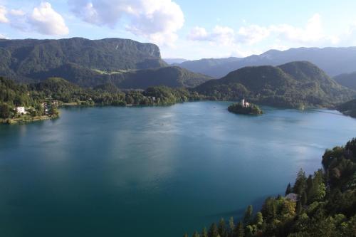 an island in the middle of a lake with mountains at Haus Lagma Studio in Železniki