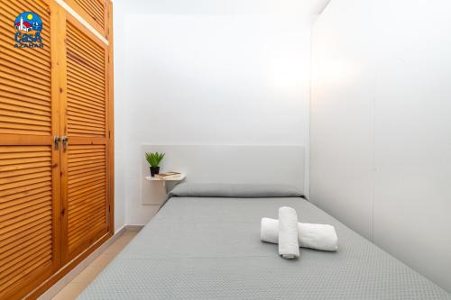 a room with a bed with two towels on it at Apartamentos Arcos II Casa Azahar in Alcossebre
