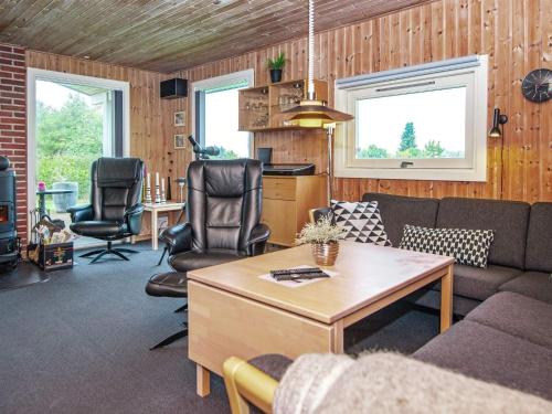 uma sala de estar com um sofá, cadeiras e uma mesa em 8 person holiday home in Glesborg em Bønnerup