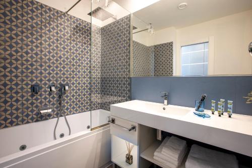 a bathroom with a sink and a shower and a mirror at La Musa Apartments & Rooms in Palermo
