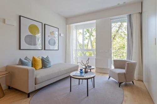 馬德里的住宿－Uma Suites O'Donnell，客厅配有沙发、桌子和椅子