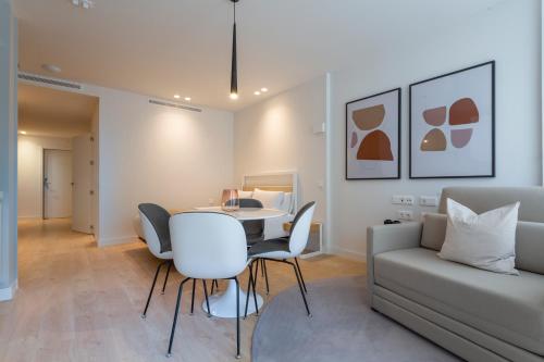 salon ze stołem, krzesłami i kanapą w obiekcie Uma Suites O'Donnell w Madrycie