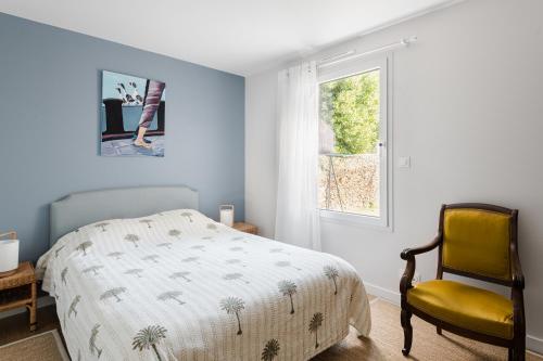 sypialnia z łóżkiem i żółtym krzesłem w obiekcie Le Herpin Cancale w mieście Cancale