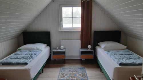 two beds in a small room with a window at Ferienhaus 'Irene' in Zerpenschleuse