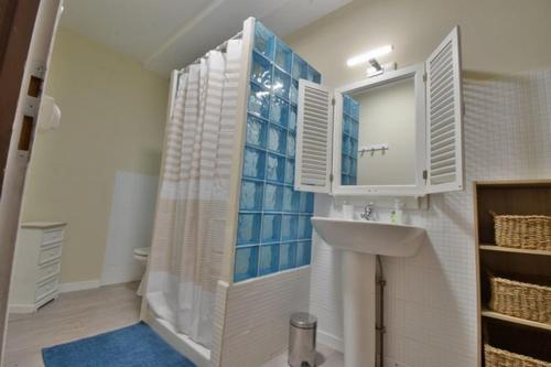 ein Bad mit einem Waschbecken und einem Spiegel in der Unterkunft Gîte Le Bon Sens - Domaine la Rose des vents in Castelnau-sur-lʼAuvignon