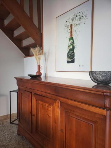 a wooden cabinet with a bottle on top of it at À la croisée des Louvières - Le Mesnil sur Oger in Le Mesnil-sur-Oger