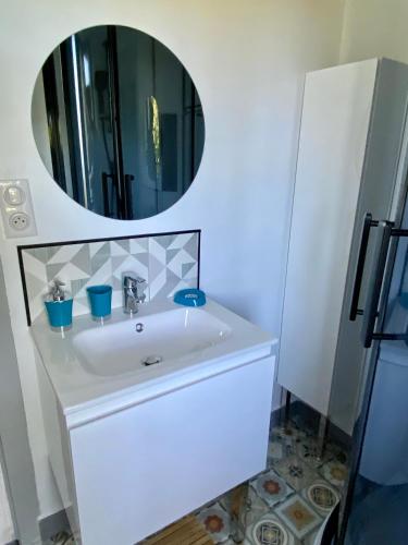 une salle de bain avec un lavabo blanc et un miroir dans l'établissement Le gîte de La Villénie - en pleine Nature - 5 min centre ville de Sarlat, à Sarlat-la-Canéda