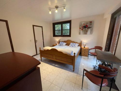 een slaapkamer met een bed en een tafel en stoelen bij Villa Agni in Barvaux
