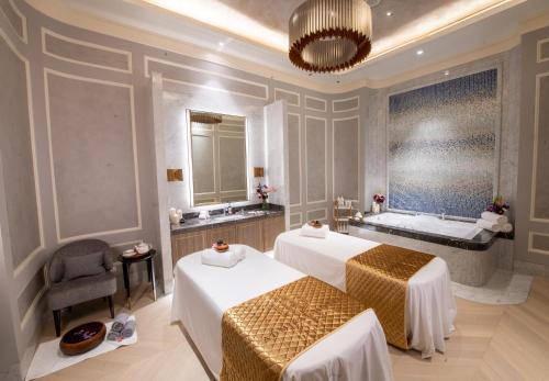 a hotel room with two beds and a bath tub at Admiral Hotel Manila - MGallery Collection in Manila
