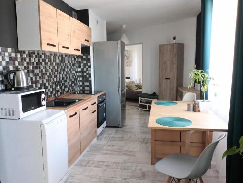 uma cozinha com um frigorífico branco e uma mesa em Apartament Leśny em Lubin