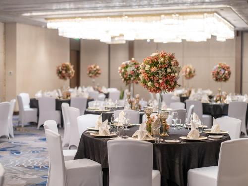 a banquet hall with tables and white chairs at Admiral Hotel Manila - MGallery Collection in Manila