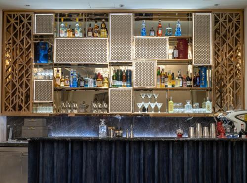 a bar with lots of bottles and alcohol at Admiral Hotel Manila - MGallery Collection in Manila