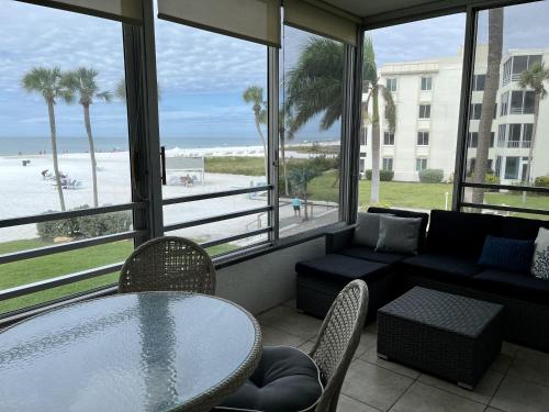 um quarto com uma mesa e cadeiras e vista para a praia em Island House Beach Resort 4S em Point O'Rocks
