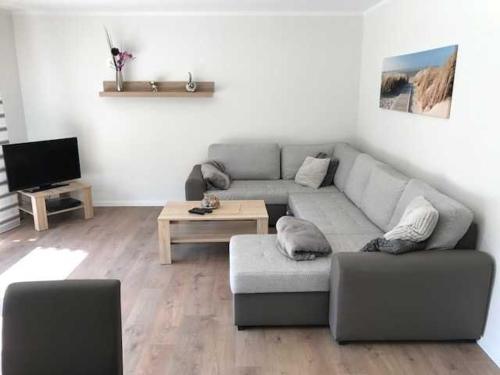 a living room with a couch and a table at Witte Huus 75m_ und 51m_ Ferienwoh in Hooksiel