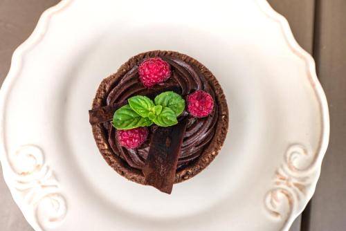 a chocolate dessert with raspberries on a white plate at Penzion U Zběhlíka in Svitavy