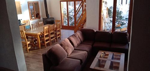 a living room with a couch and a dining room at Maison cœur tarentaise in Les Chapelles
