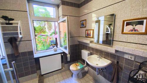uma casa de banho com um lavatório, um WC e uma janela. em Kamoro em Trier
