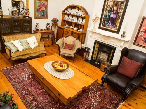 a living room with a coffee table and a fireplace at KAROOWERF GUEST HOUSE in Cradock