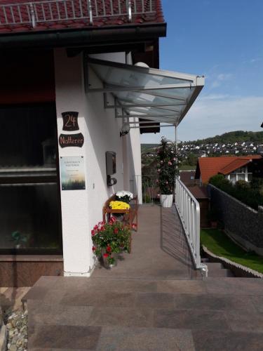 um edifício com toldo e flores num alpendre em Gästehaus Natterer - FeWo 2 em Momlingen