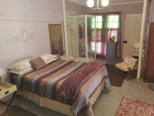 a bedroom with a bed and a bathroom at KAROOWERF GUEST HOUSE in Cradock