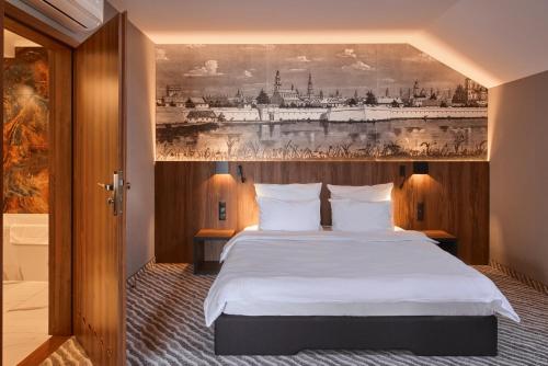 ザモシチにあるArtis Hotel & Spaのベッドルーム1室(壁に絵画が描かれたベッド1台付)