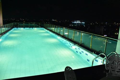 a swimming pool on the roof of a building at night at BNB RESIDENCIES NAWALA in Nawala
