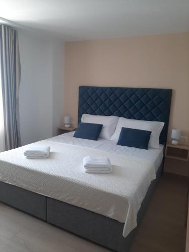 a bedroom with a large bed with two towels on it at Šangulin Palace M in Biograd na Moru