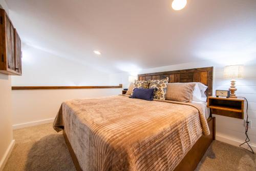 a bedroom with a large bed with a wooden headboard at The Nuthatch Cabin 15 MIN to Magnolia Baylor in Elm Mott