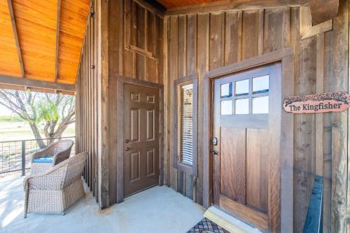 een houten huis met een deur en een bord erop bij The Roadrunner Cabin 15MIN to Magnolia Baylor 