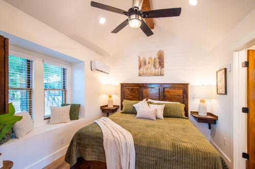 a bedroom with a bed and a ceiling fan at The Wren Treehouse 15 MIN to Magnolia Baylor 