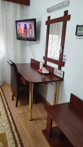 a living room with a table and a tv on the wall at Pensiunea Select in Arad