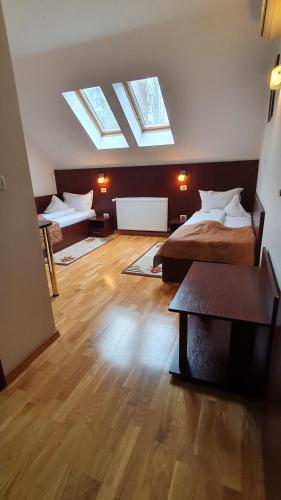 a bedroom with two beds with skylights and wooden floors at Pensiunea Select in Arad