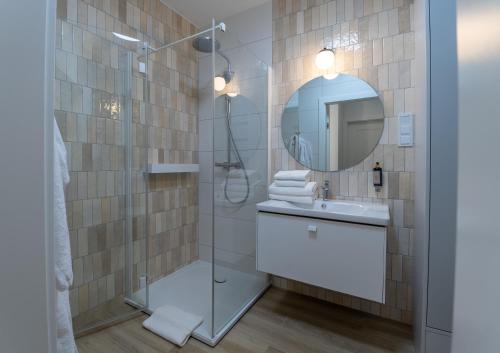 a bathroom with a shower and a sink and a mirror at POLANKI AQUA Apartamenty PREMIUM - w cenie nielimitowany dostęp do strefy Aqua in Kołobrzeg
