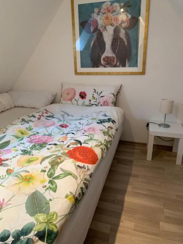 a bed in a room with a picture of a cow at Ferienwohnung Lüttje Hörn in Emden