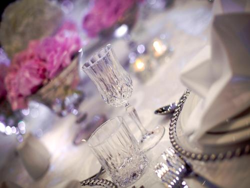 a couple of glasses sitting on a table with flowers at The Art Hotel & Resort in Manama