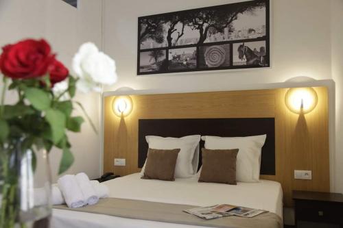 Kasbah的住宿－Hotel de la Poste，一间卧室配有一张床和一个红色玫瑰花瓶