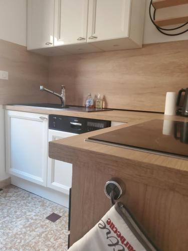 a kitchen with white cabinets and a black dishwasher at À la croisée des Louvières - Le Mesnil sur Oger in Le Mesnil-sur-Oger