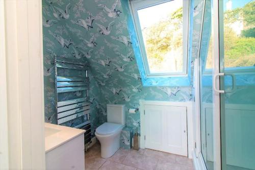 a bathroom with a toilet and a window at The luxury Beach property - Oceanbreeze in Sandgate