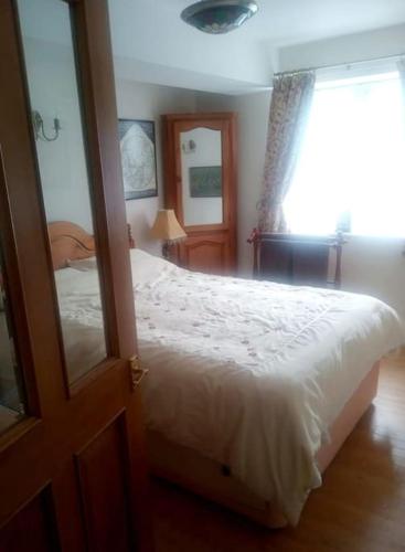 a bedroom with a white bed and a window at Charming, wonderfully cosy one bedroom apartment in Giggleswick