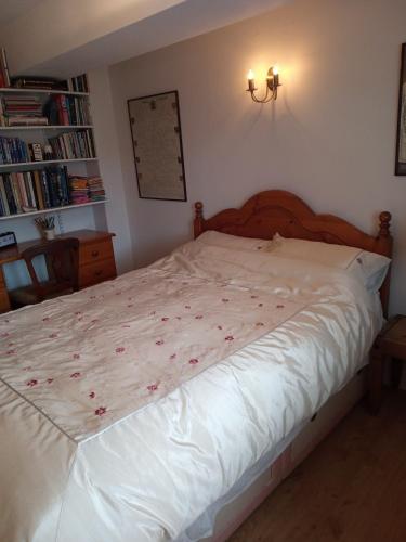 a bedroom with a white bed with red flowers on it at Charming, wonderfully cosy one bedroom apartment in Giggleswick