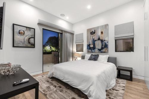 Orlando Estate في لوس أنجلوس: غرفة نوم بيضاء مع سرير كبير وطاولة