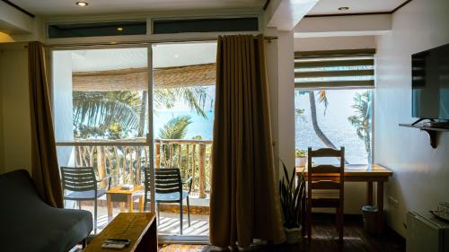 a living room with a large window and a table and chairs at DiveGurus Boracay Beach Resort in Boracay