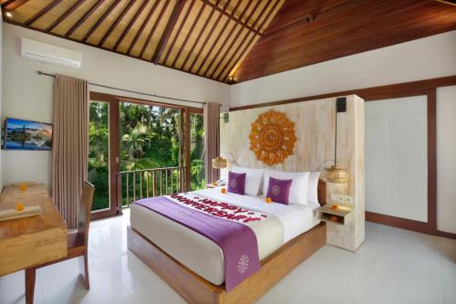 a bedroom with a king sized bed and a desk at Dedary Resort Ubud by Ini Vie Hospitality in Ubud