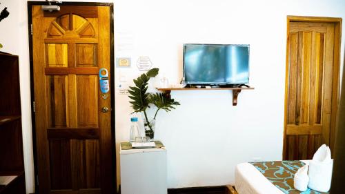 a room with a bed and a tv on a wall at DiveGurus Boracay Beach Resort in Boracay