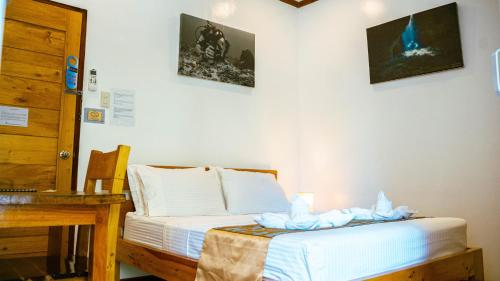 a room with a bed and a table and a desk at DiveGurus Boracay Beach Resort in Boracay