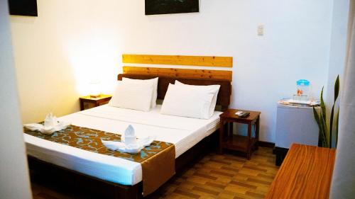 a bedroom with a bed with two white birds on it at DiveGurus Boracay Beach Resort in Boracay